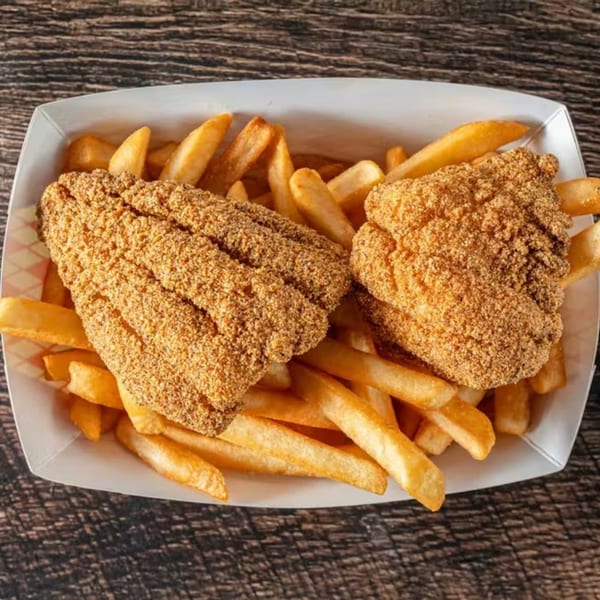 Two pieces of breaded fried fish and a pile of french fries in a white paper tray.
