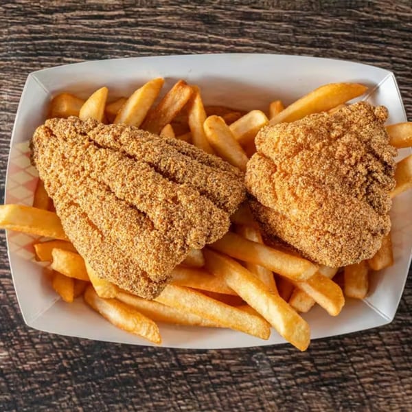 Two pieces of breaded fried fish and a pile of golden french fries in a white paper tray.
